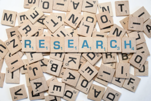 A mixture of scrabble tiles spells out the word research